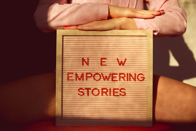 a person holding a sign that says new empowering stories